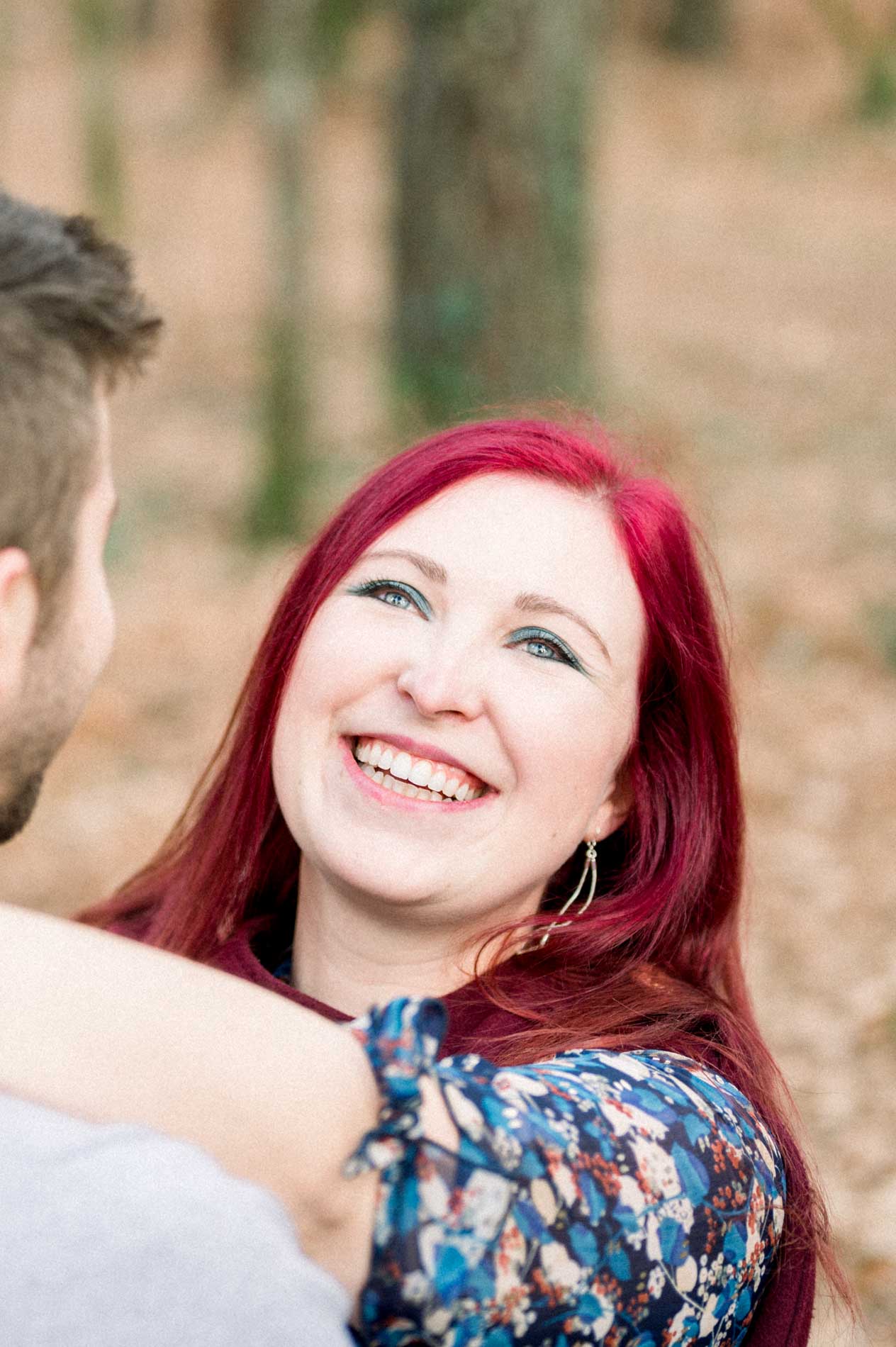 Red-haired woman laughing in her partner's arms