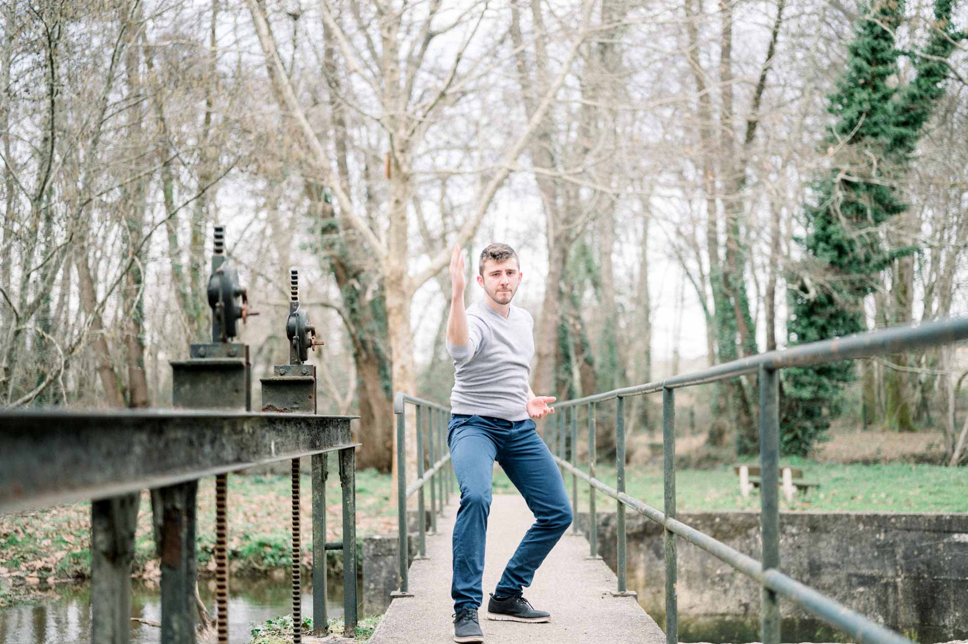 Man in a chanbara fighting pose on the footbridge, arm raised