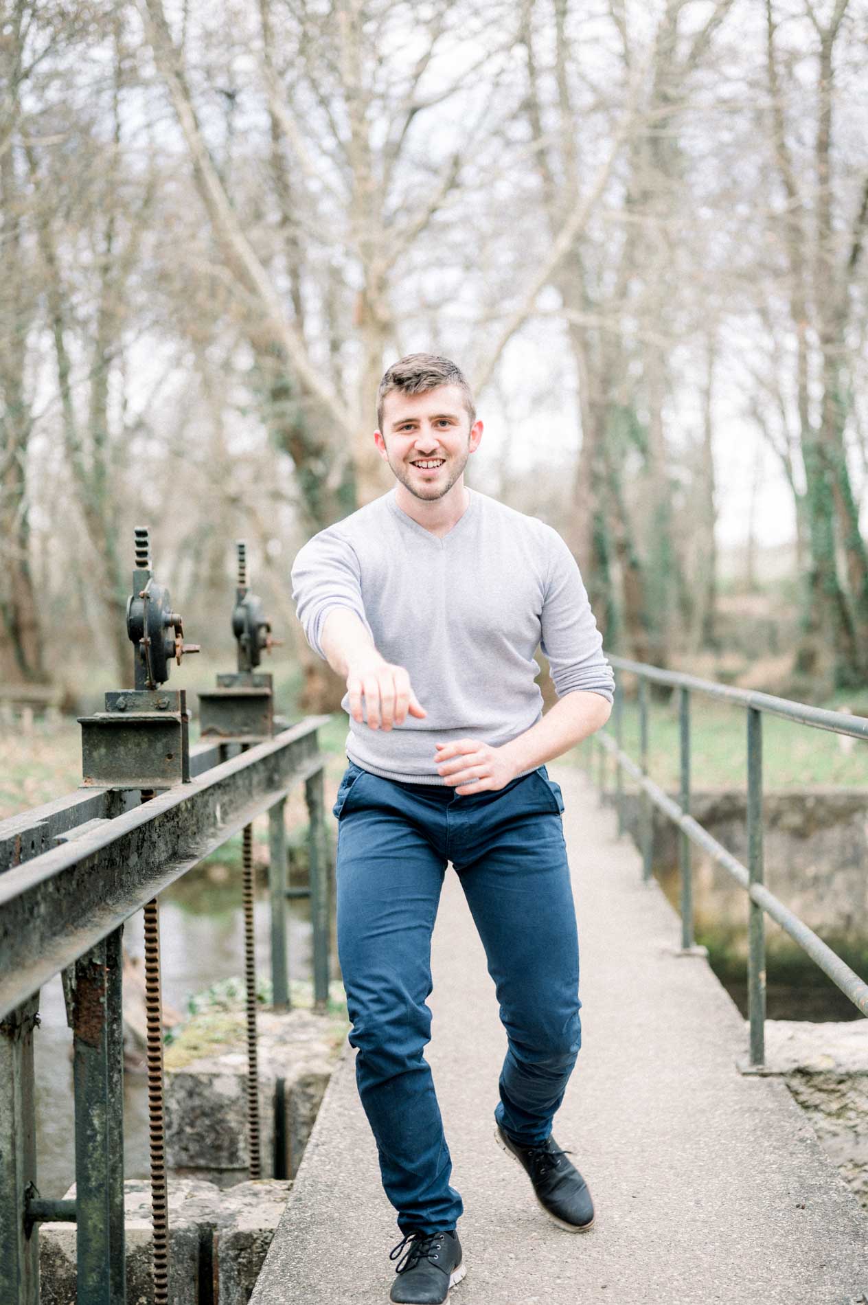 Man stepping forward in a fighting stance on a metal footbridge