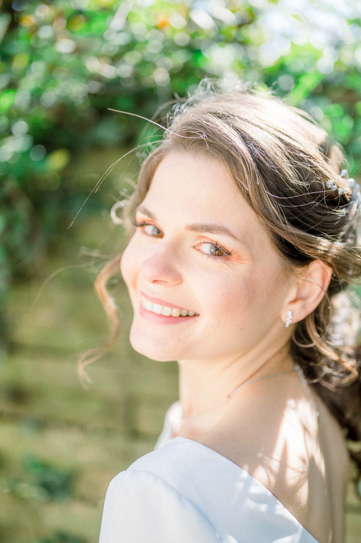 Portrait de la mariée regardant par-dessus son épaule, chignon bohème
