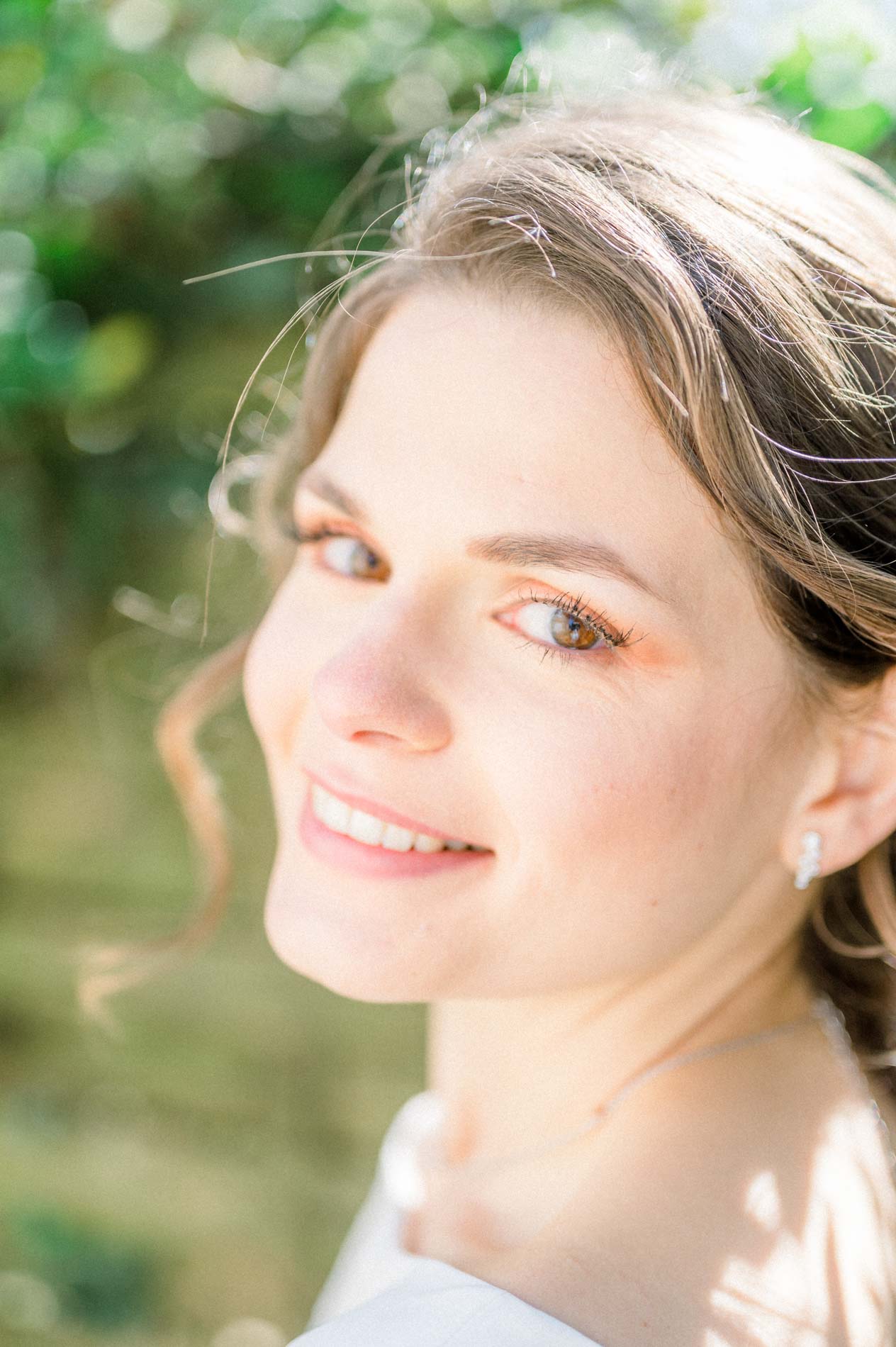 Gros plan du sourire de la mariée dans la lumière de printemps