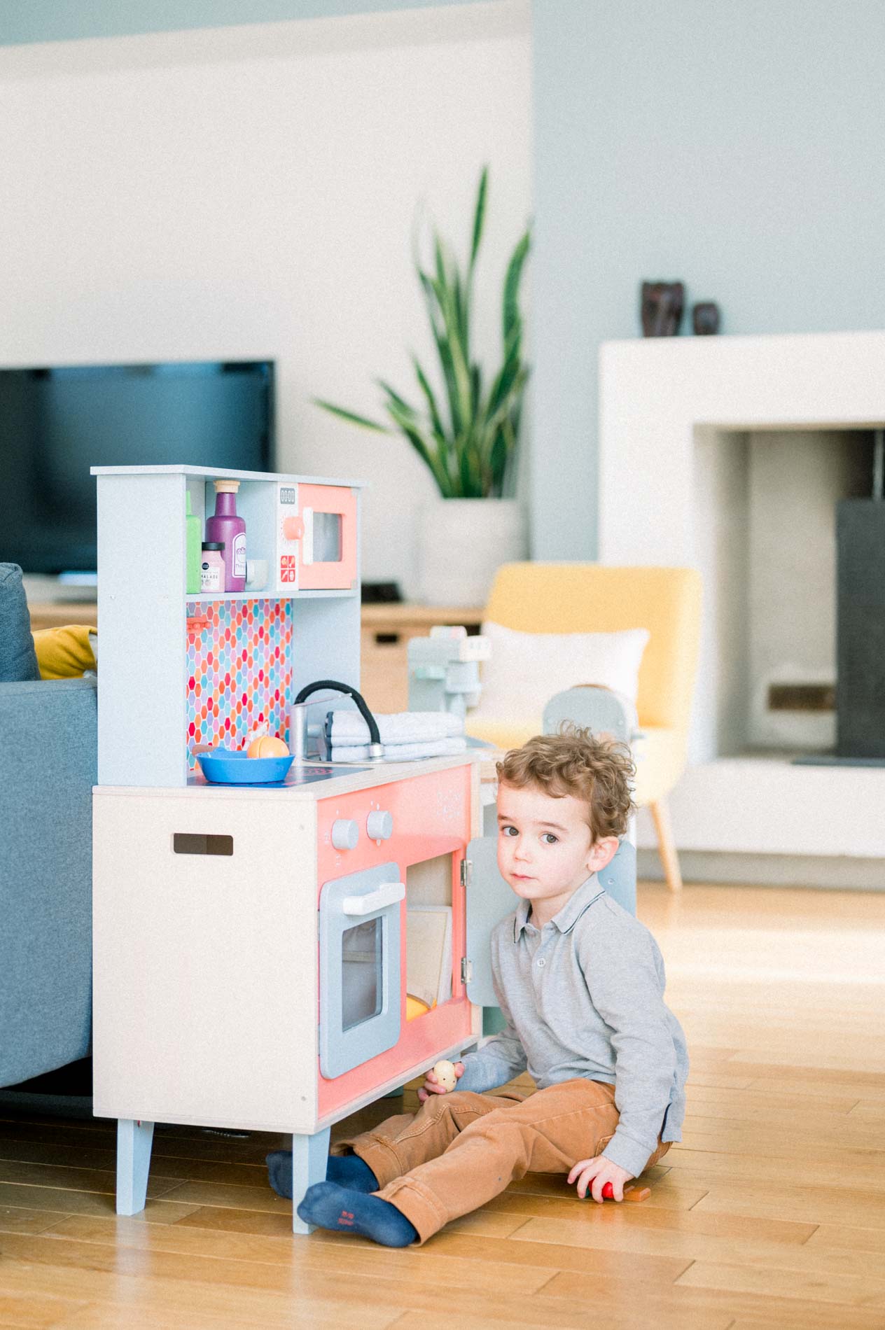 Petit garçon jouant à la cuisine en bois dans le salon