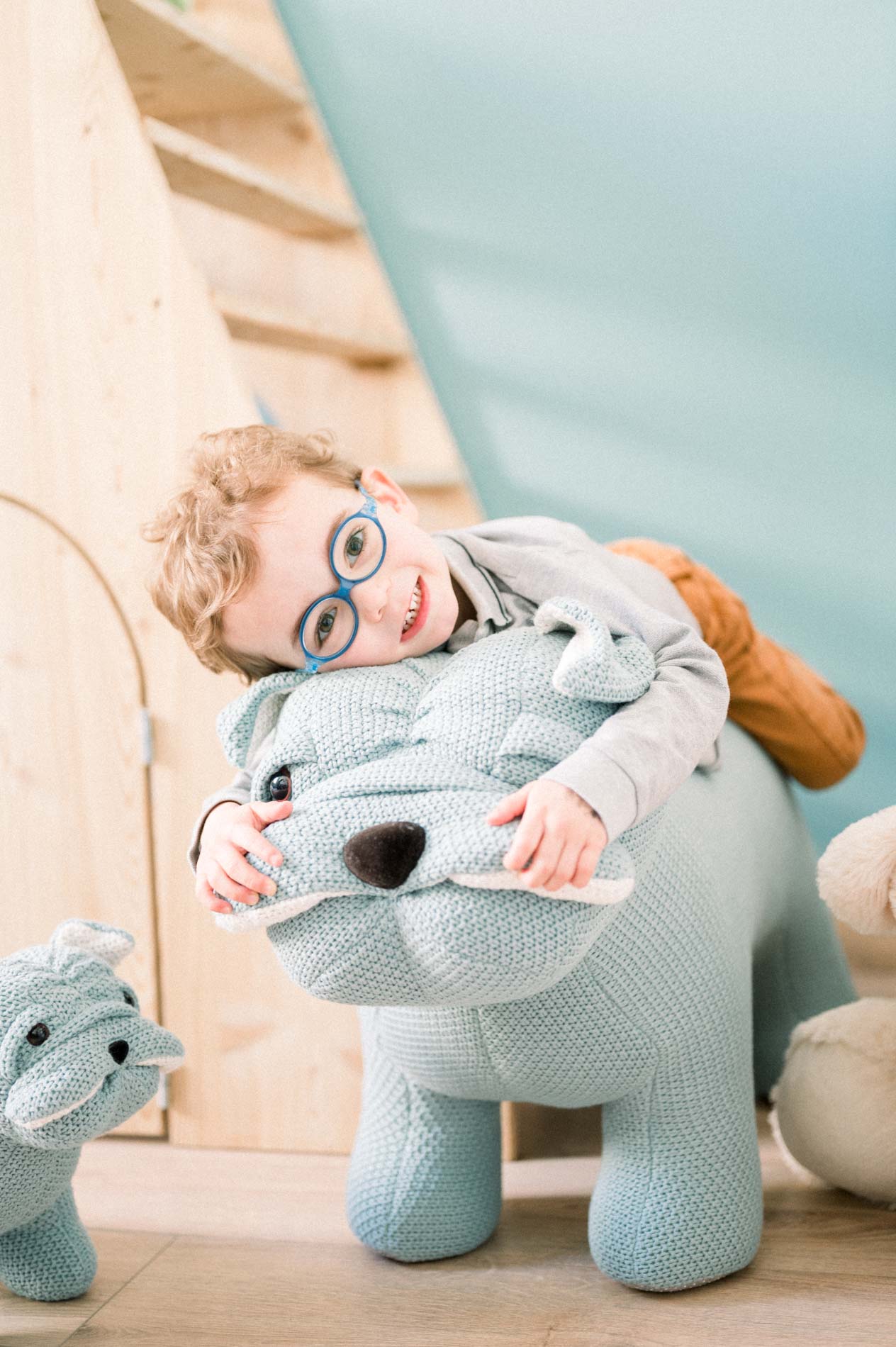 Petit garçon à lunettes à cheval sur un éléphant en tricot