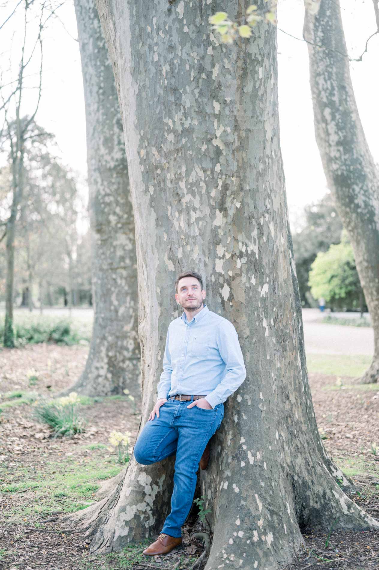The father leaning against the trunk of a large plane tree in Parc Bordelais
