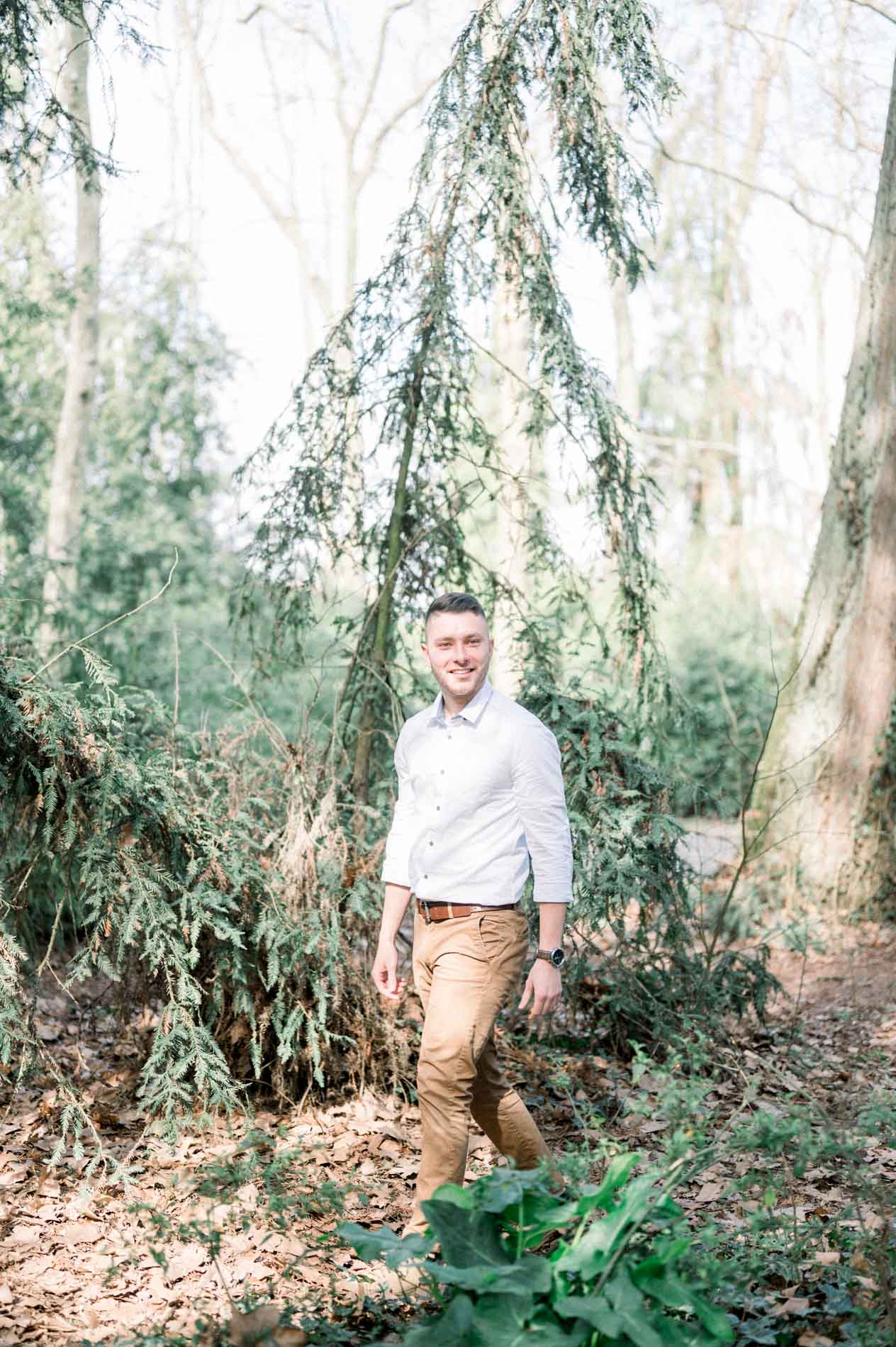 The brother in a white shirt walking through the woodland
