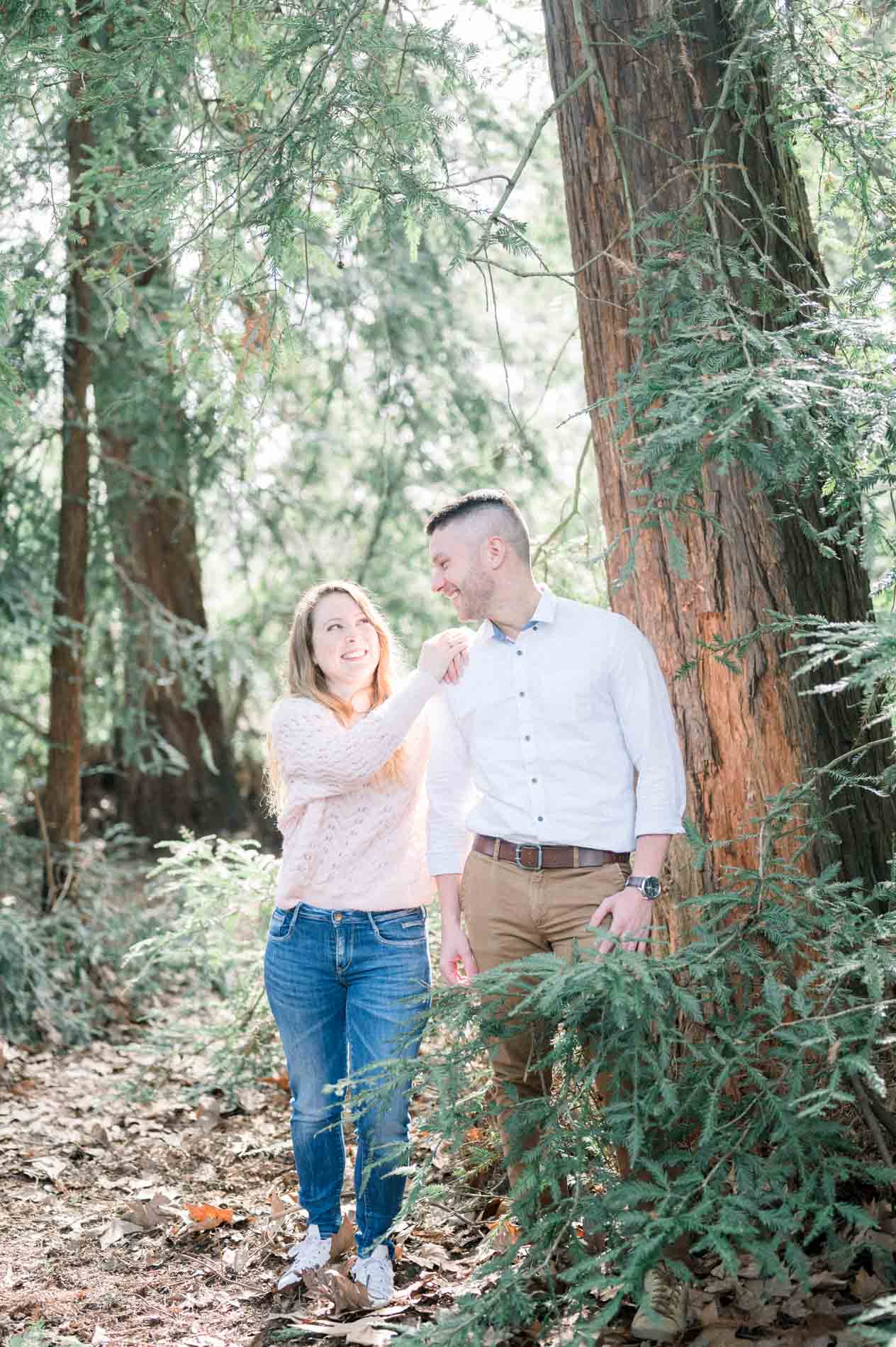 Brother and sister sharing a laugh at the foot of a redwood during the shoot