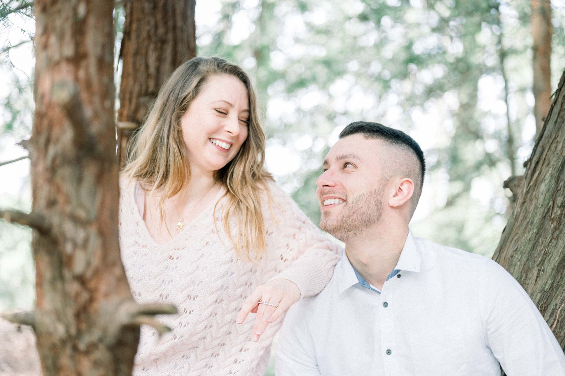 Brother and sister sitting by the trunks, exchanging a laughing glance