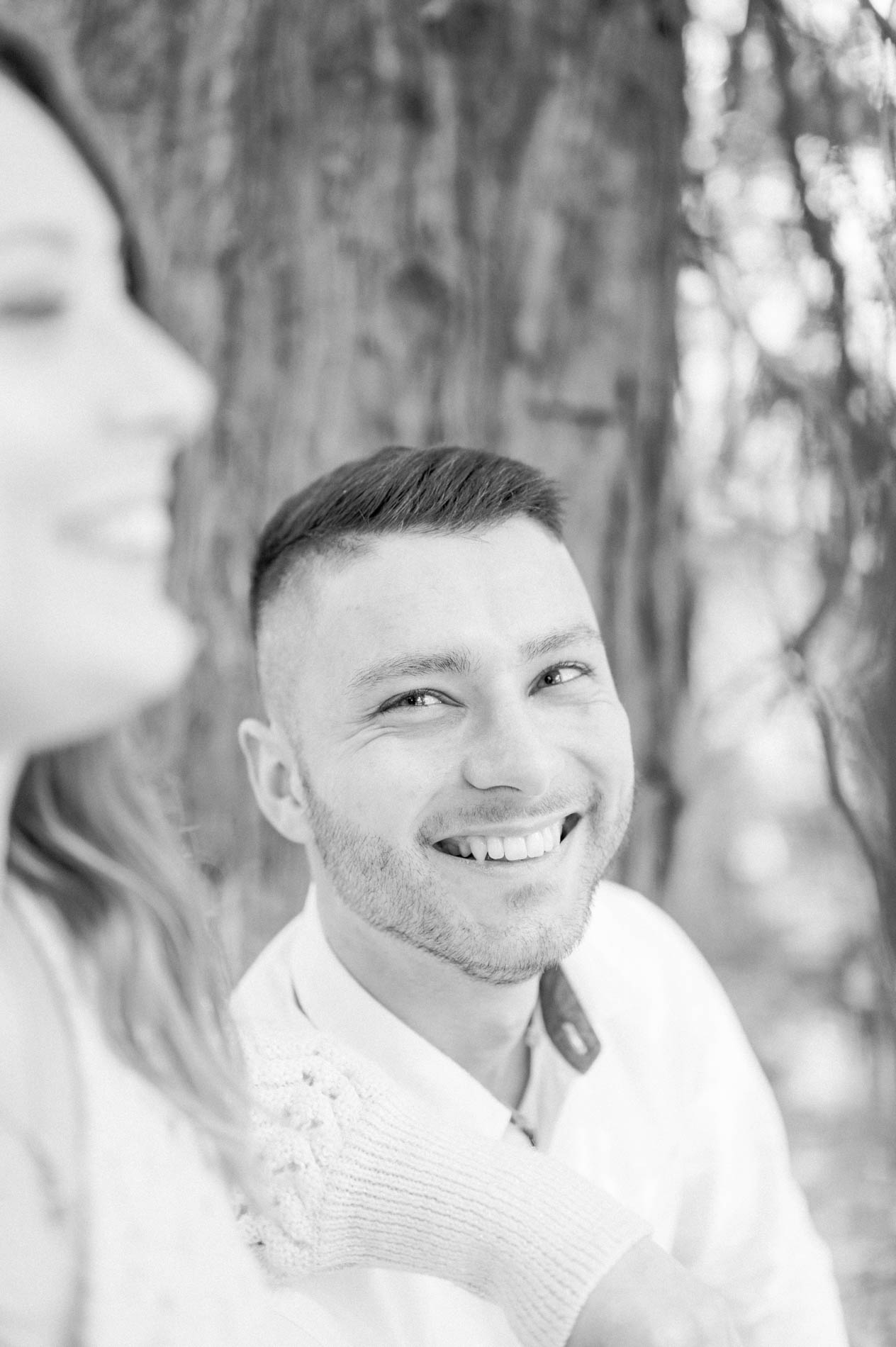 The brother smiling beside his sister in the foreground, black and white