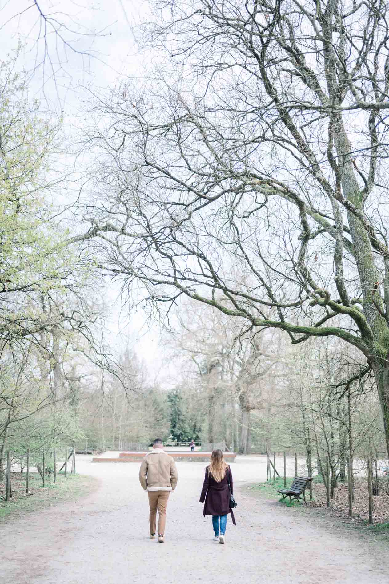 Brother and sister walking side by side along a wide avenue in Parc Bordelais