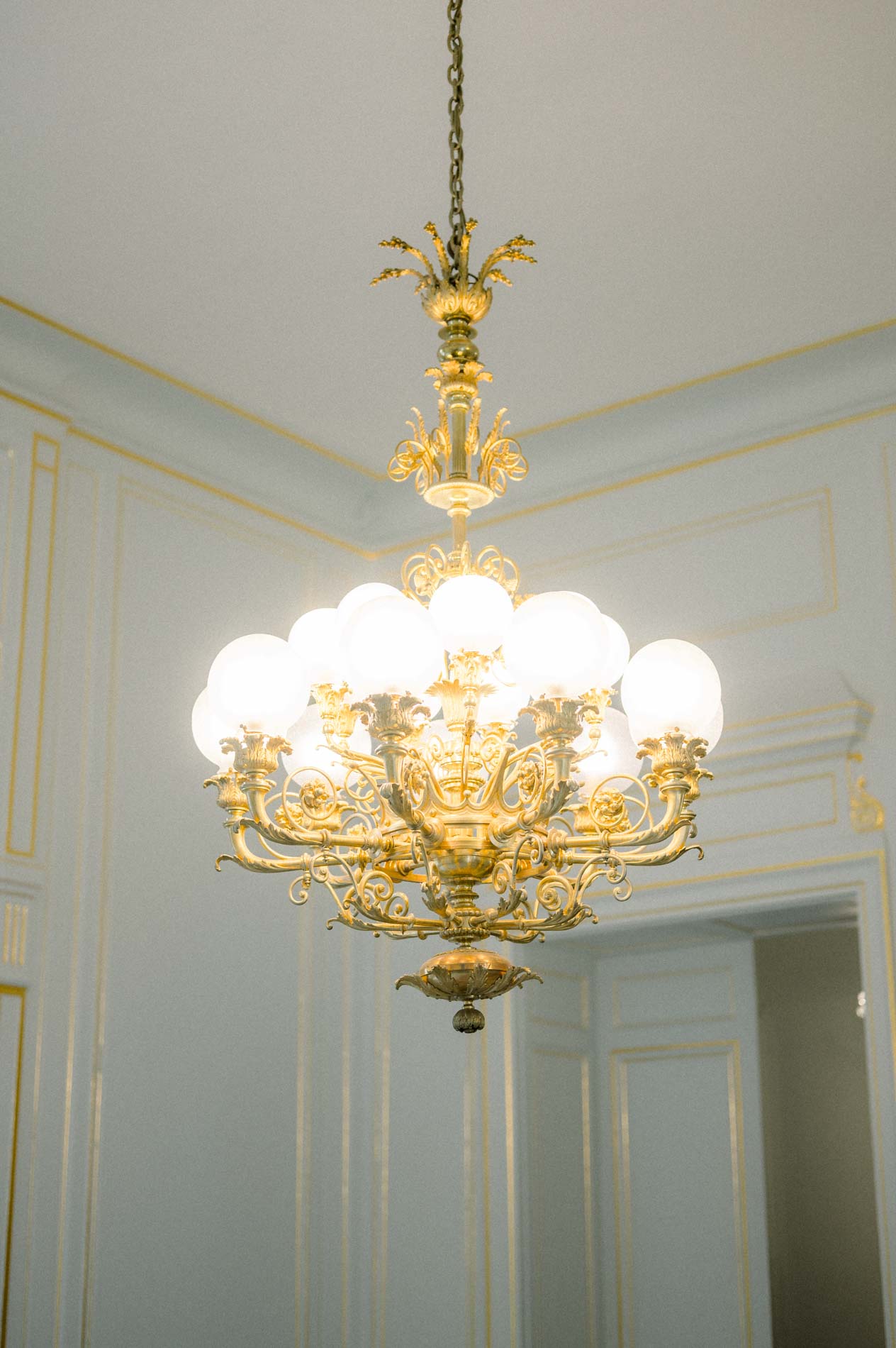 Gilded chandelier in a white salon of Bordeaux city hall