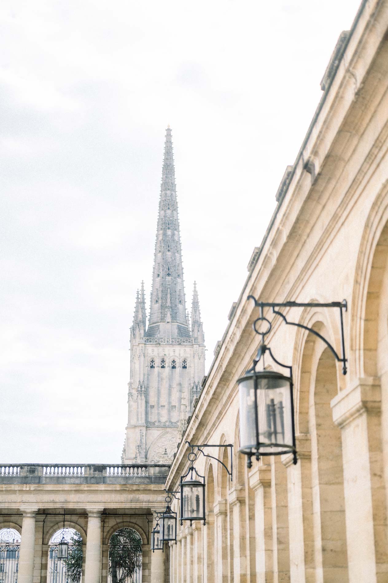 Gothic spire and colonnade lanterns seen from the city hall courtyard