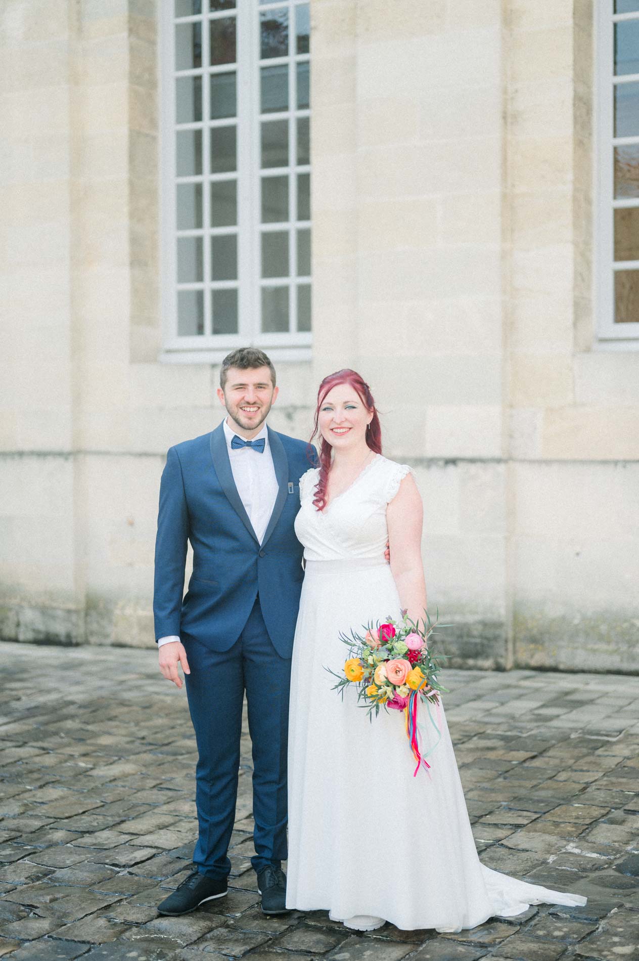 Bride and groom side by side on the cobbles of the Bordeaux city hall courtyard