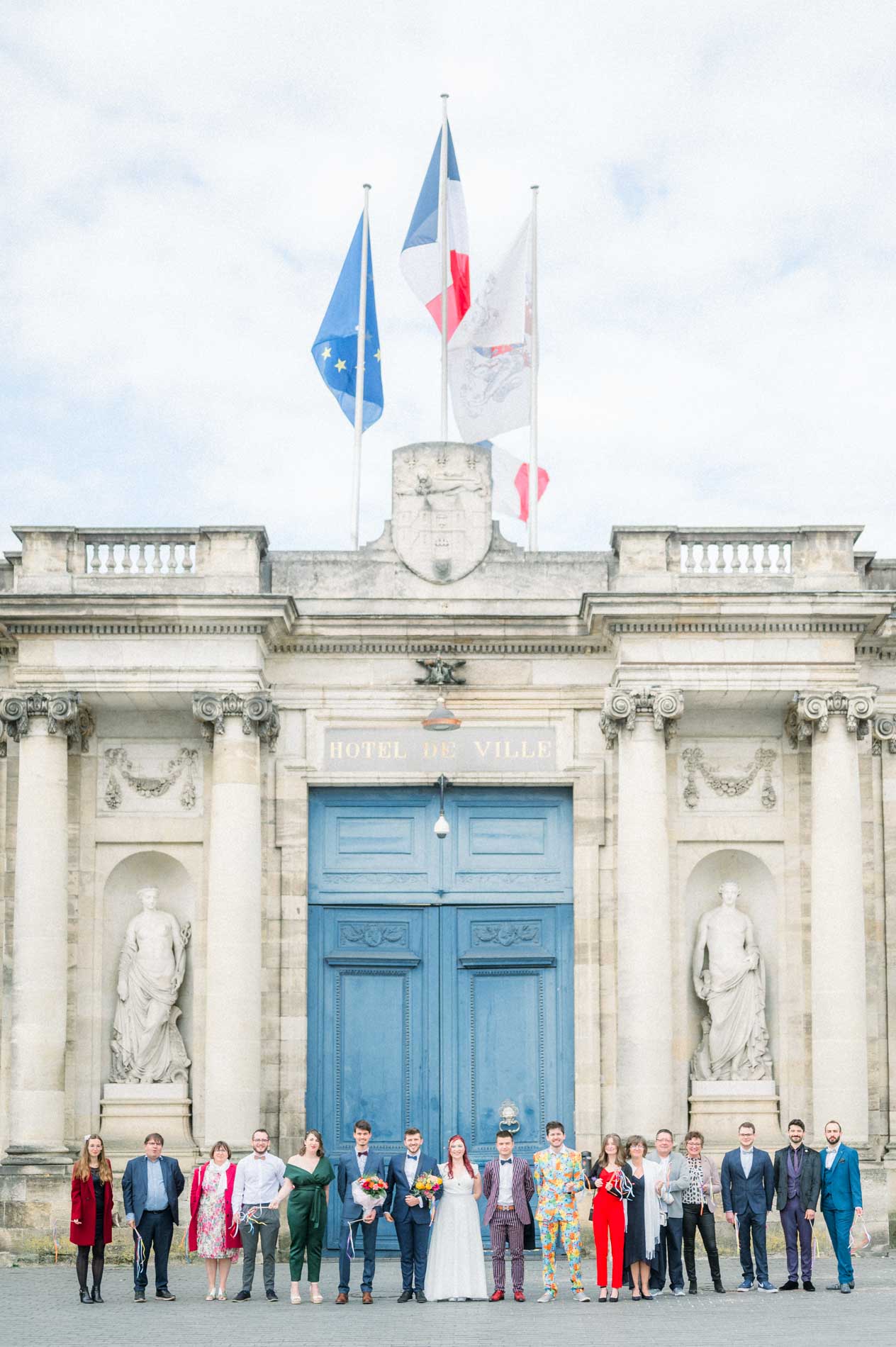 Guests lined up before the blue gate and flags of city hall