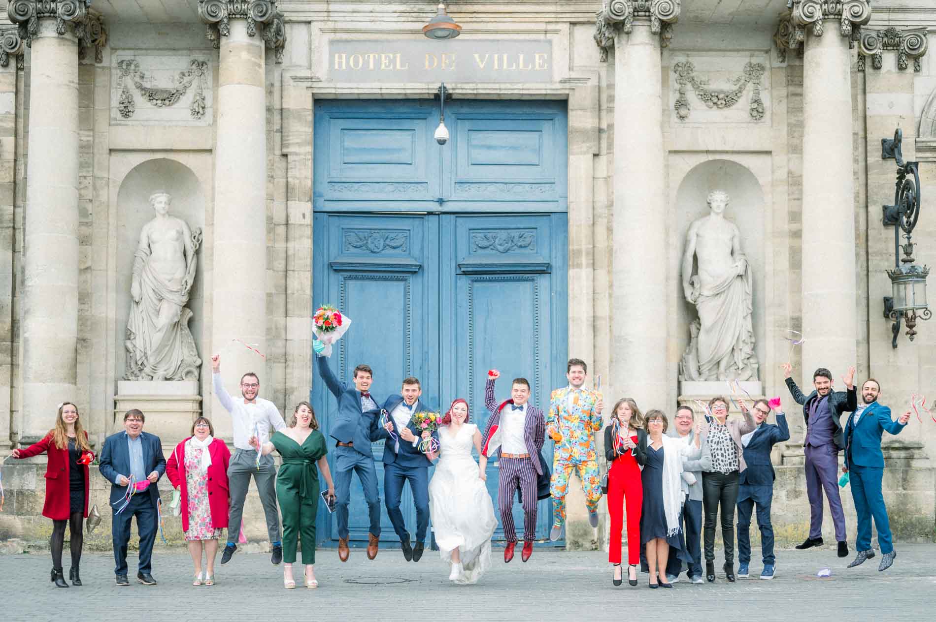 Tiffa and Geo with their guests, arms raised outside Bordeaux city hall