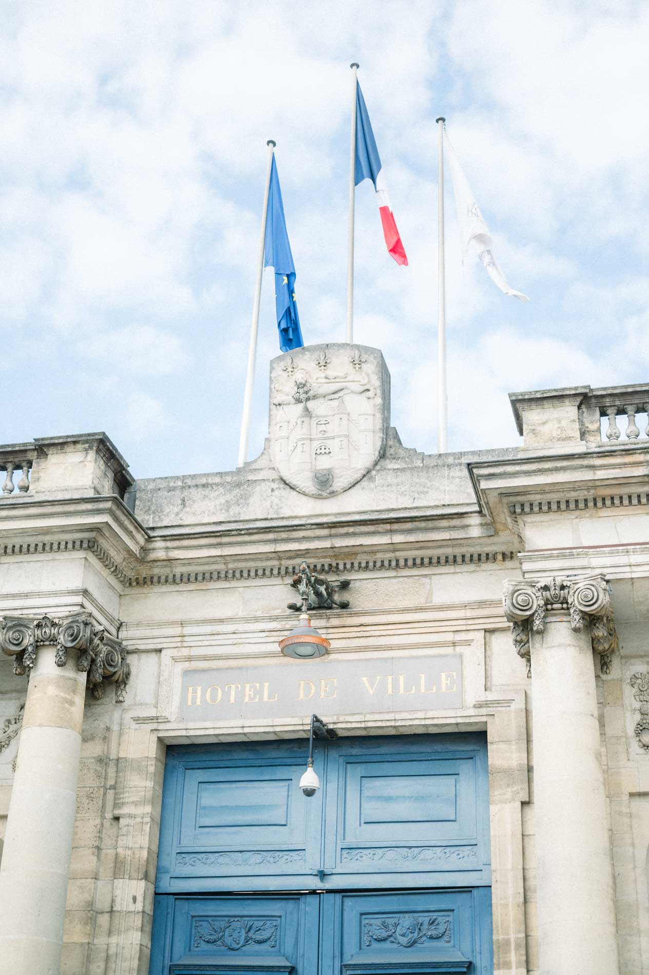 Entrance of Bordeaux Hôtel de Ville with its blue gate and flags