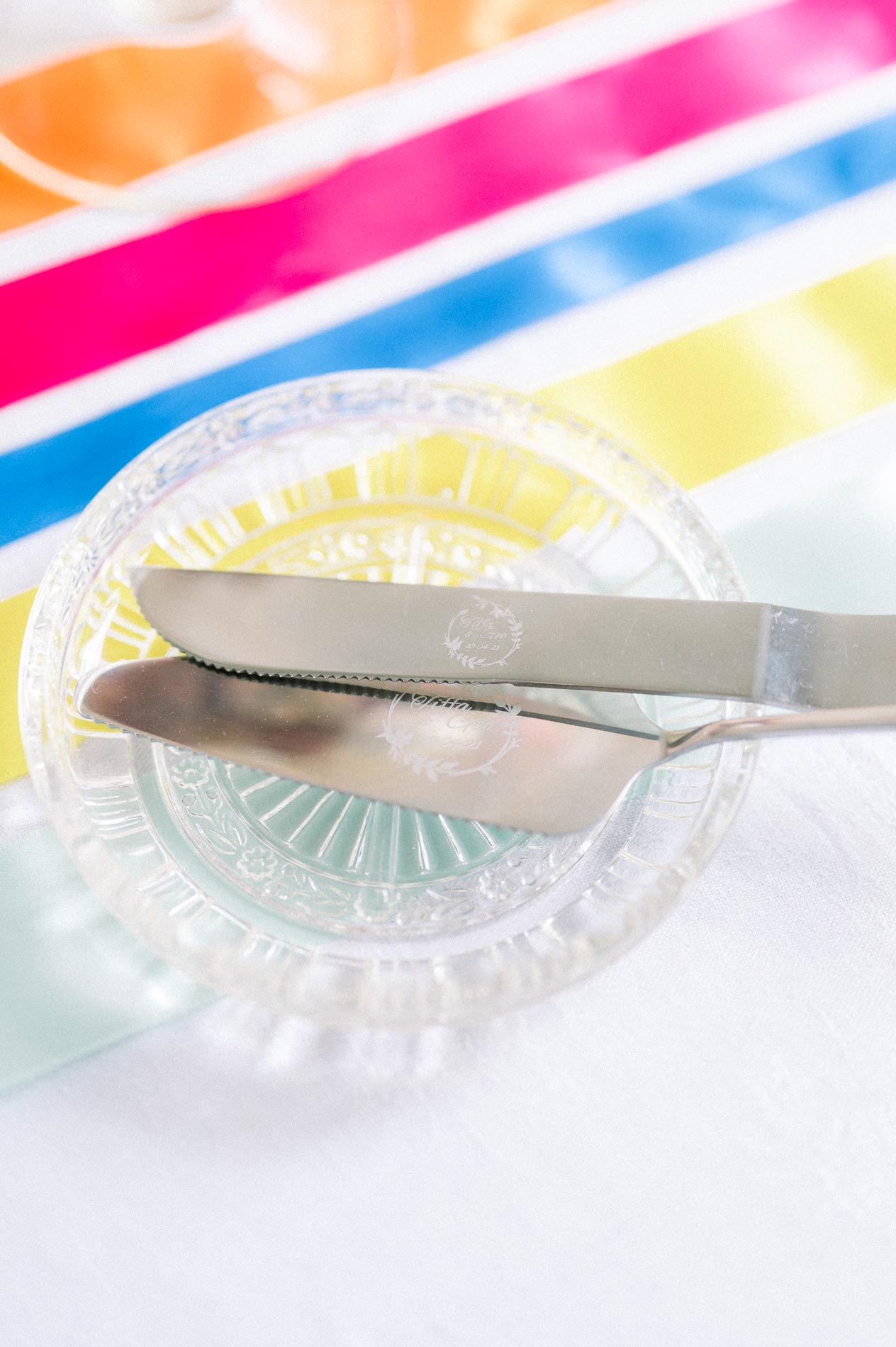 Cut-glass knives resting on a rainbow ribbon