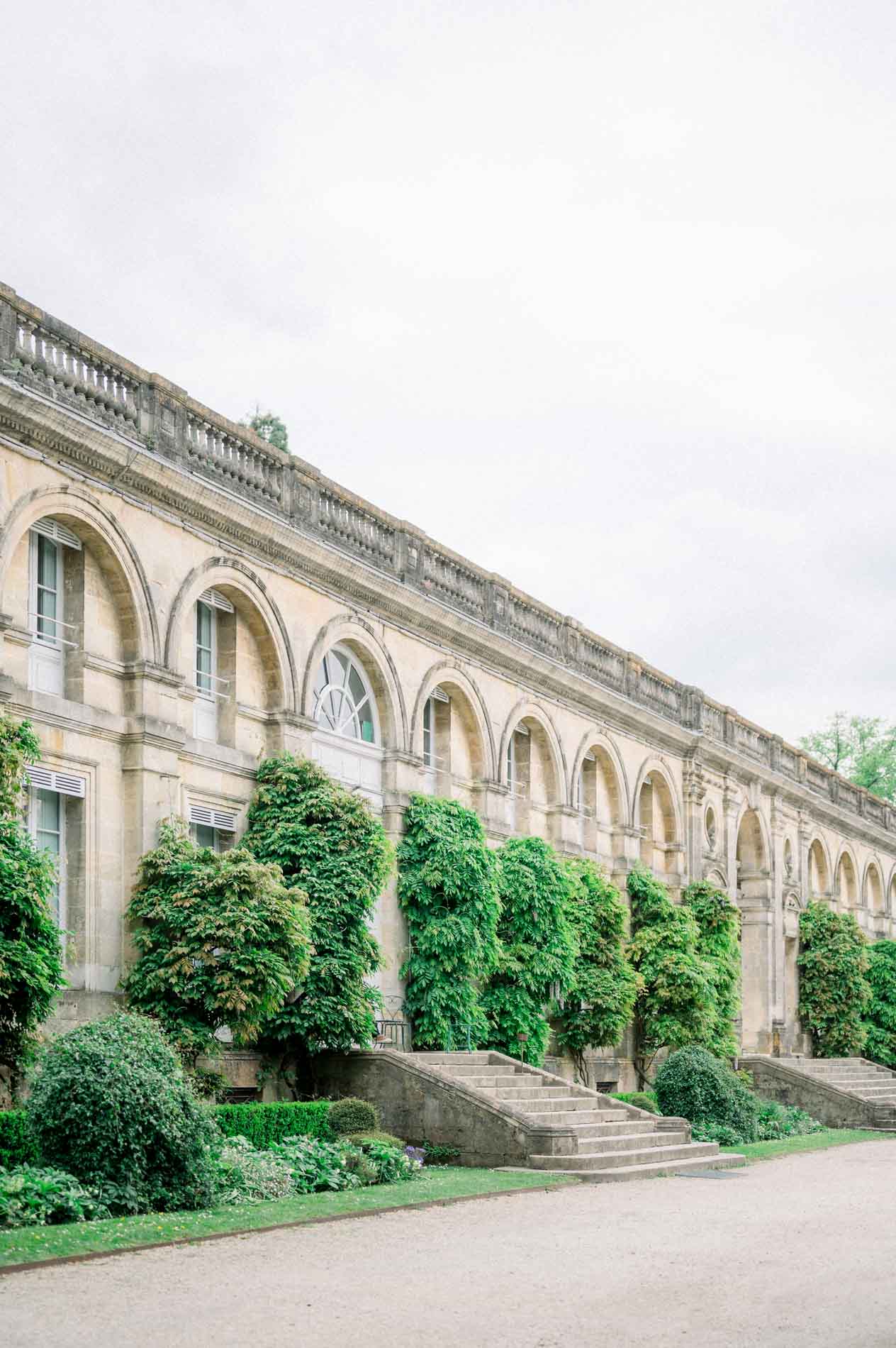 Galerie à arcades et massifs verts de l'orangerie du Jardin Public de Bordeaux