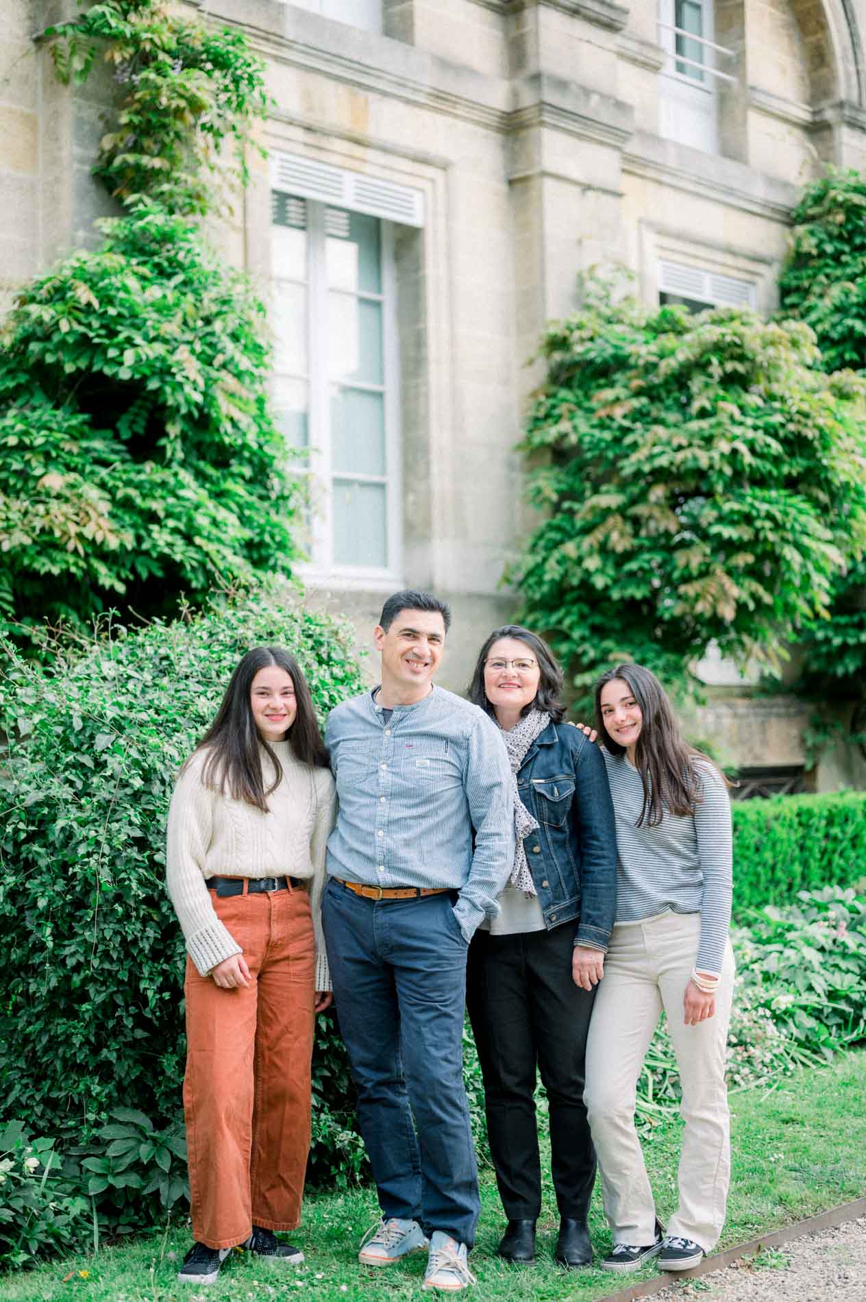 La famille réunie devant les grandes fenêtres de l'orangerie, en cadrage vertical
