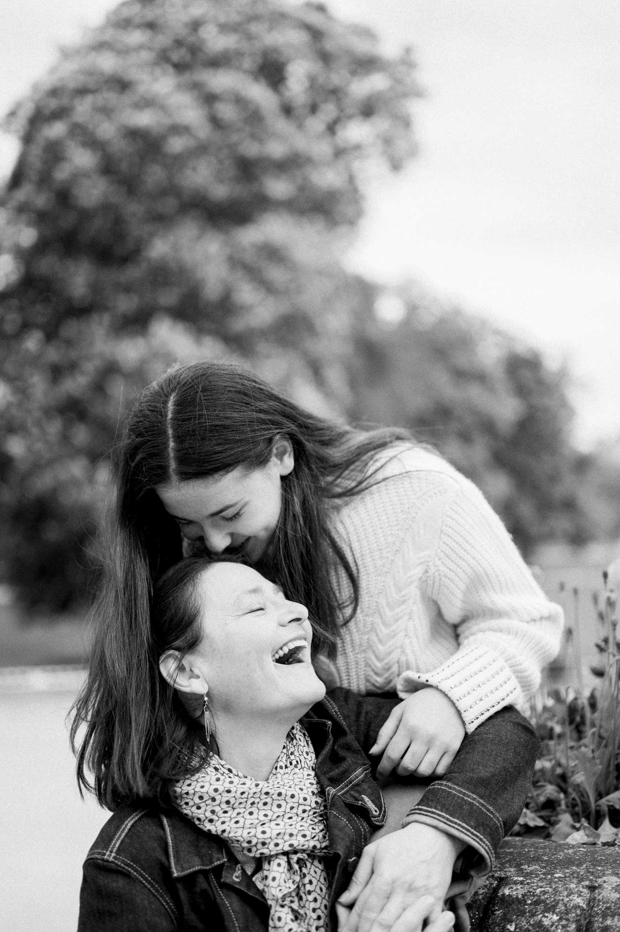 Une jeune femme enlace une femme plus âgée, toutes deux en éclats de rire