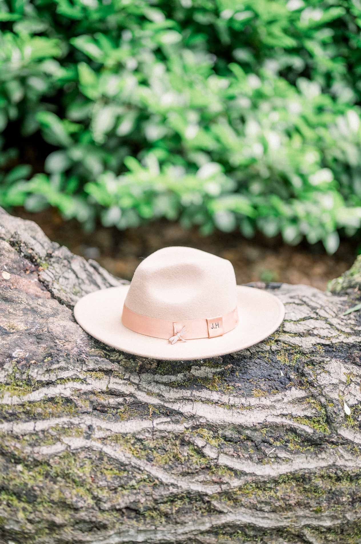 Beige felt hat resting on a moss-covered tree trunk