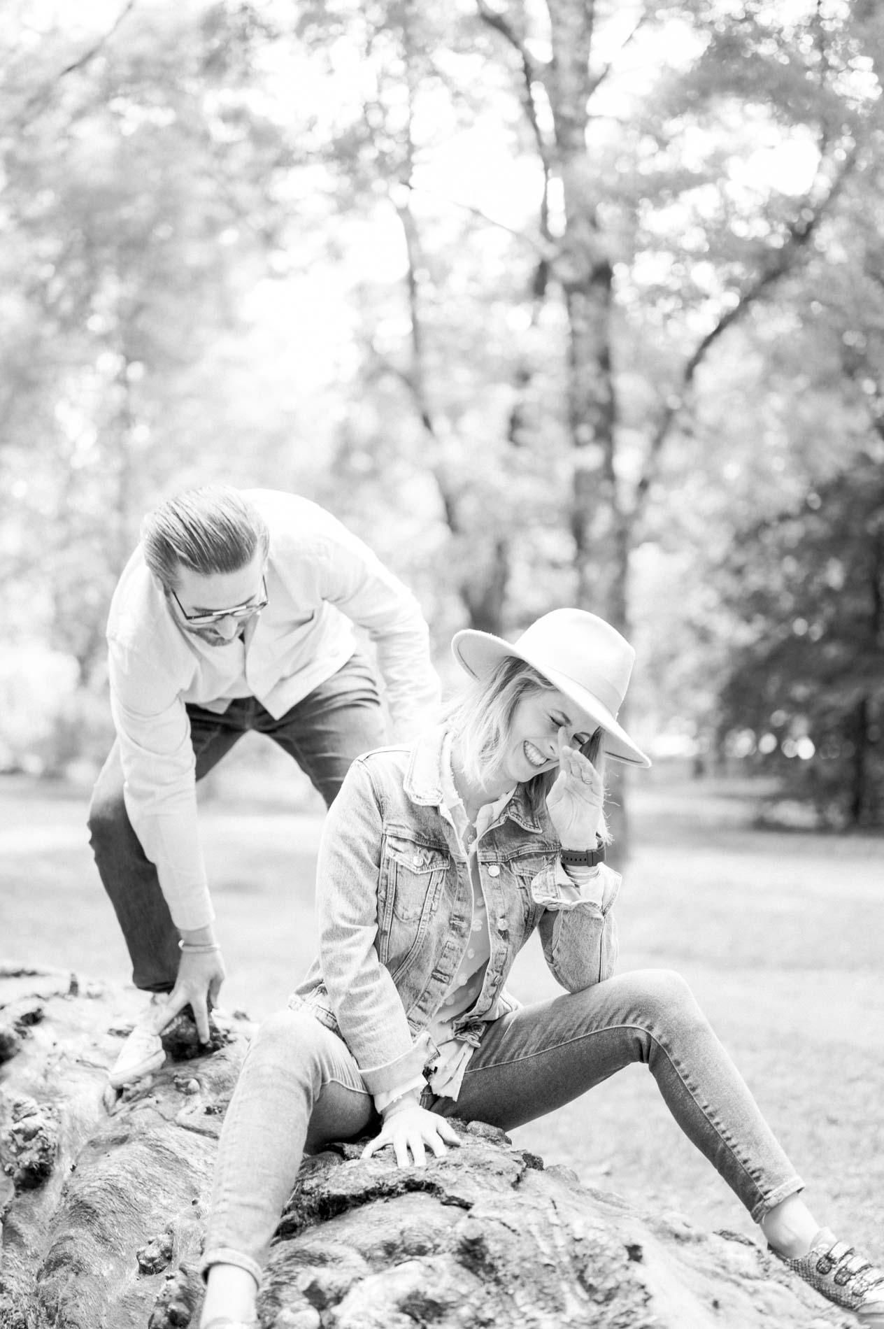 The father helping the mother down from the trunk, in black and white