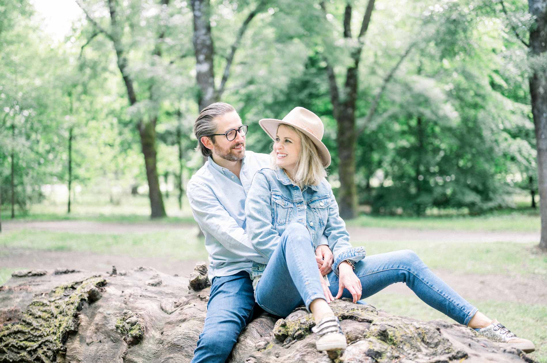 Parents sitting on a fallen tree trunk during a family photo session at Parc Bordelais