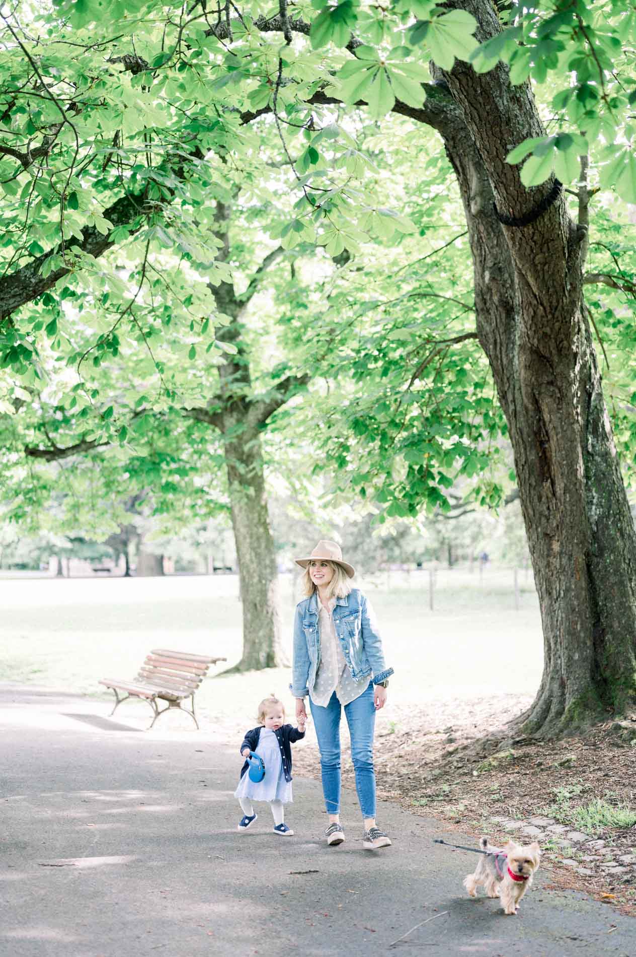 The mother and her daughter walking their little dog in the park