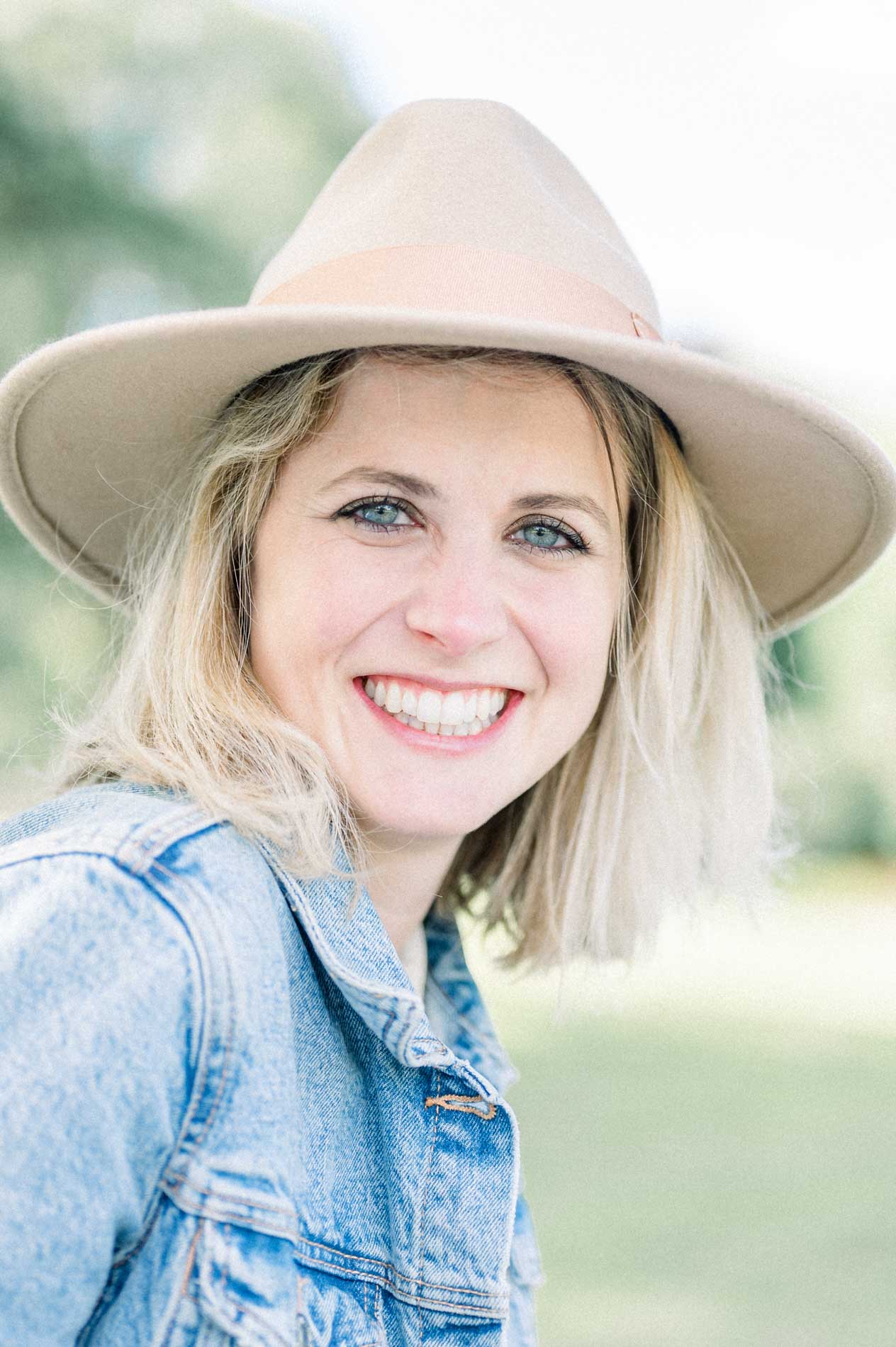 Bright portrait of the smiling mother in a beige hat