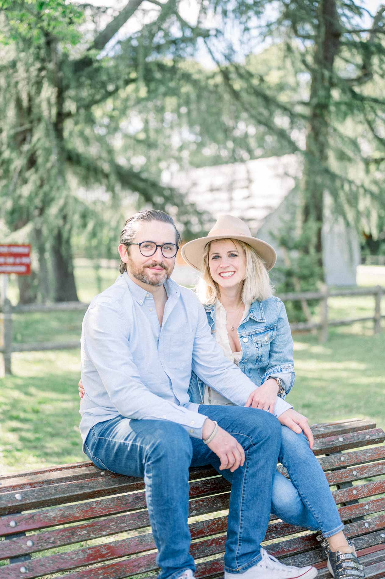 The smiling parents sitting close together on a park bench in Bordeaux