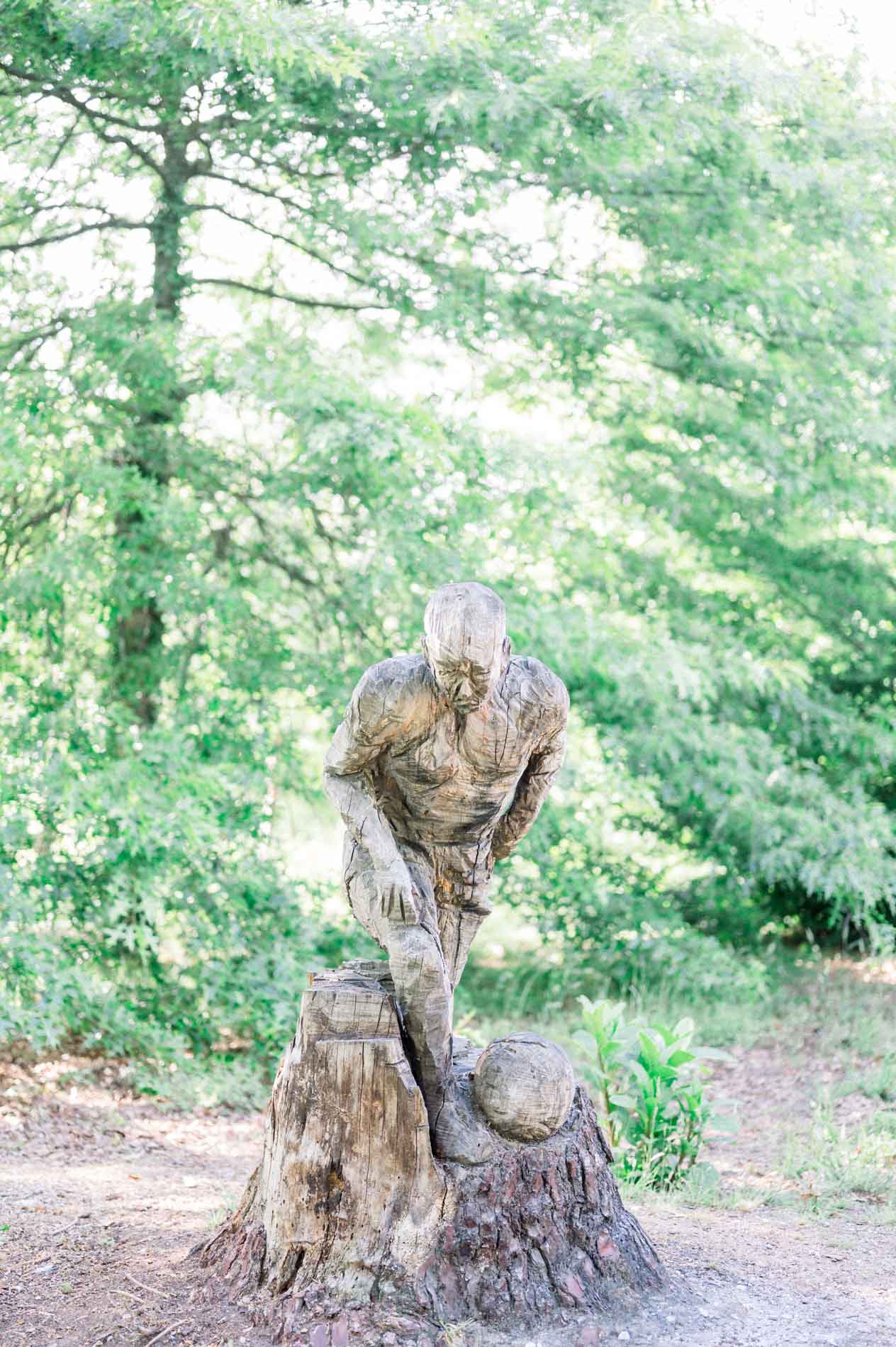 Carved wooden statue among the trees at Domaine de Pinsan