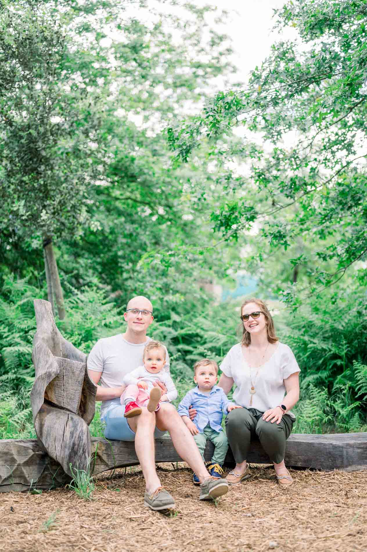 Family portrait seated on a wooden bench in the park