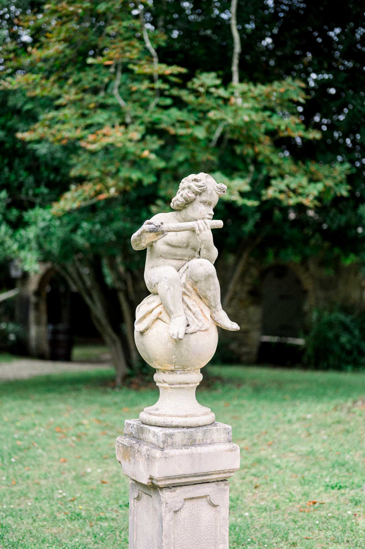 Cherub statue on a pedestal in the Chartreuse des Eyres garden