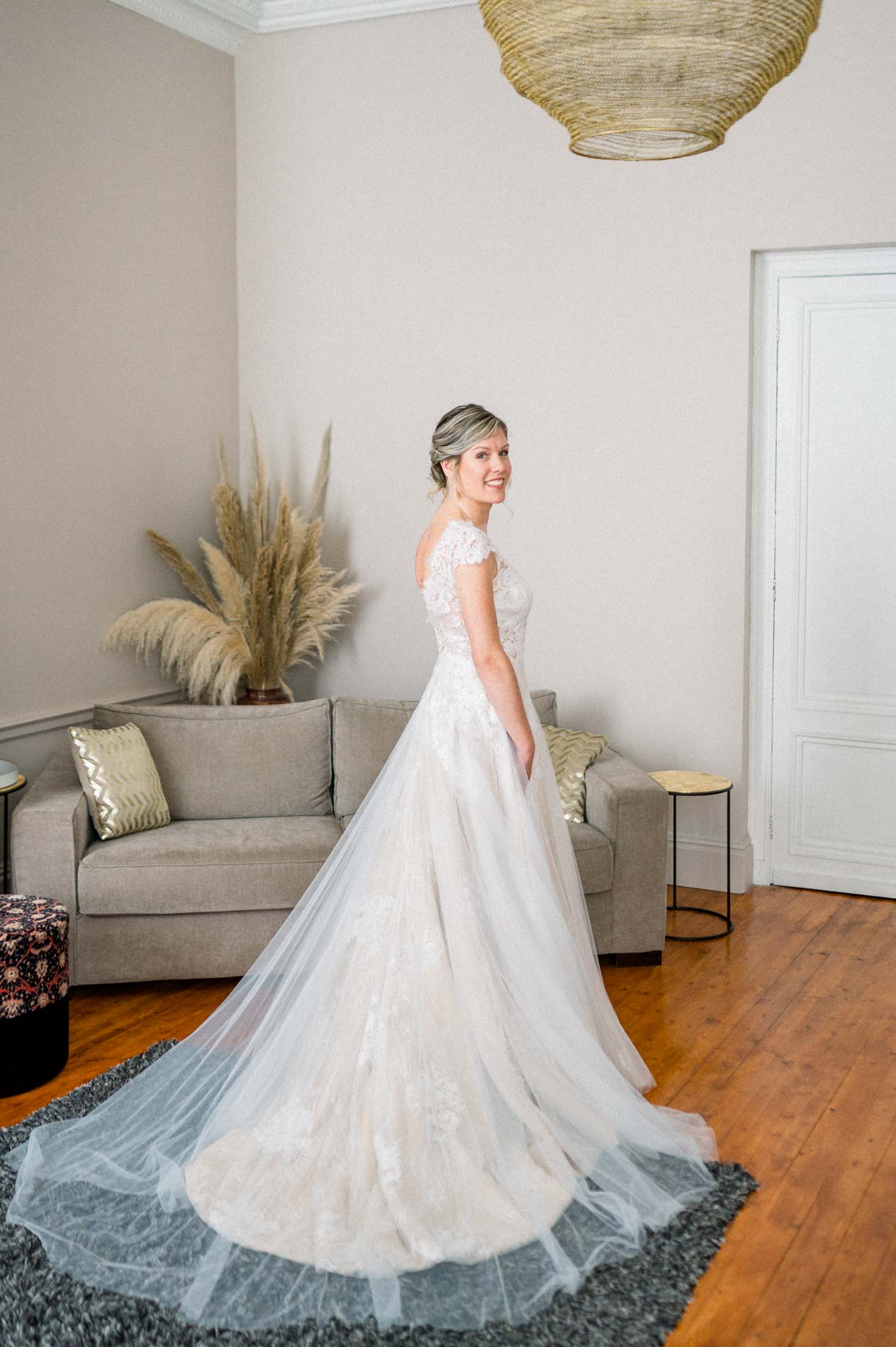 Bride in a long-trained gown in a bright lounge at the Chartreuse