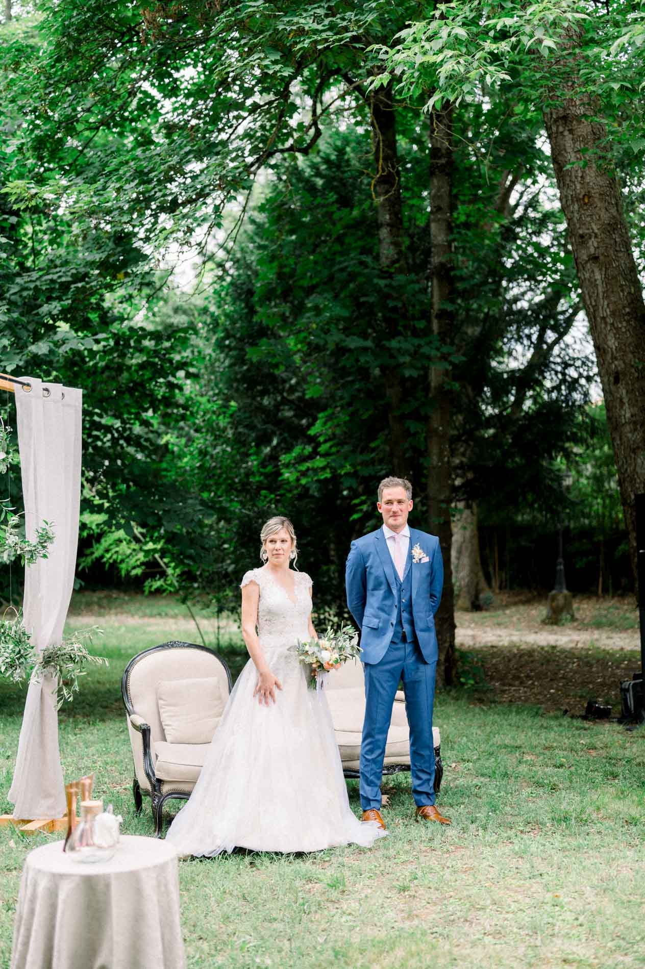 Emilie and Aurelien facing their guests during the outdoor ceremony under the trees