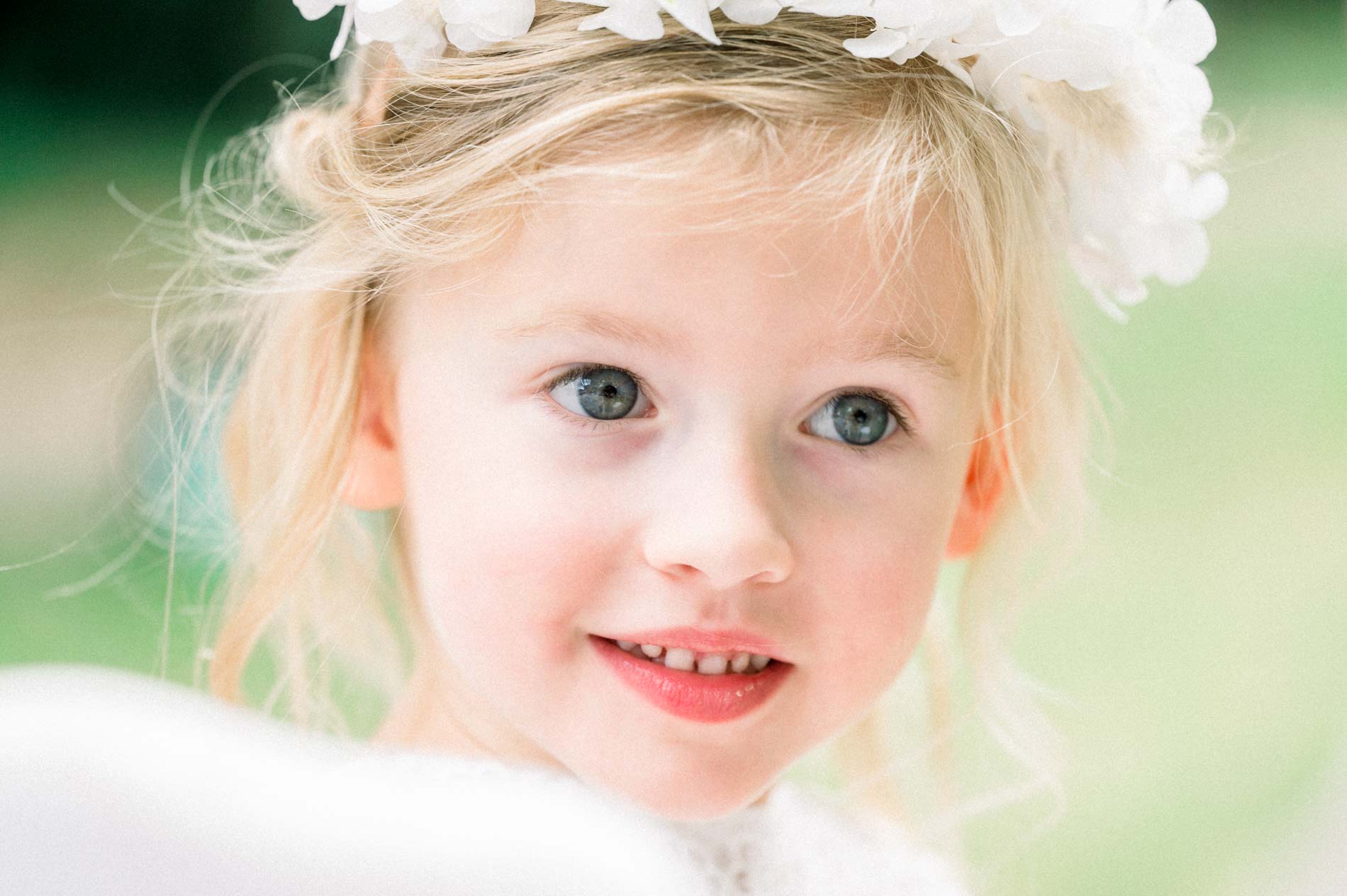 Little blonde girl wearing a flower crown during the ceremony