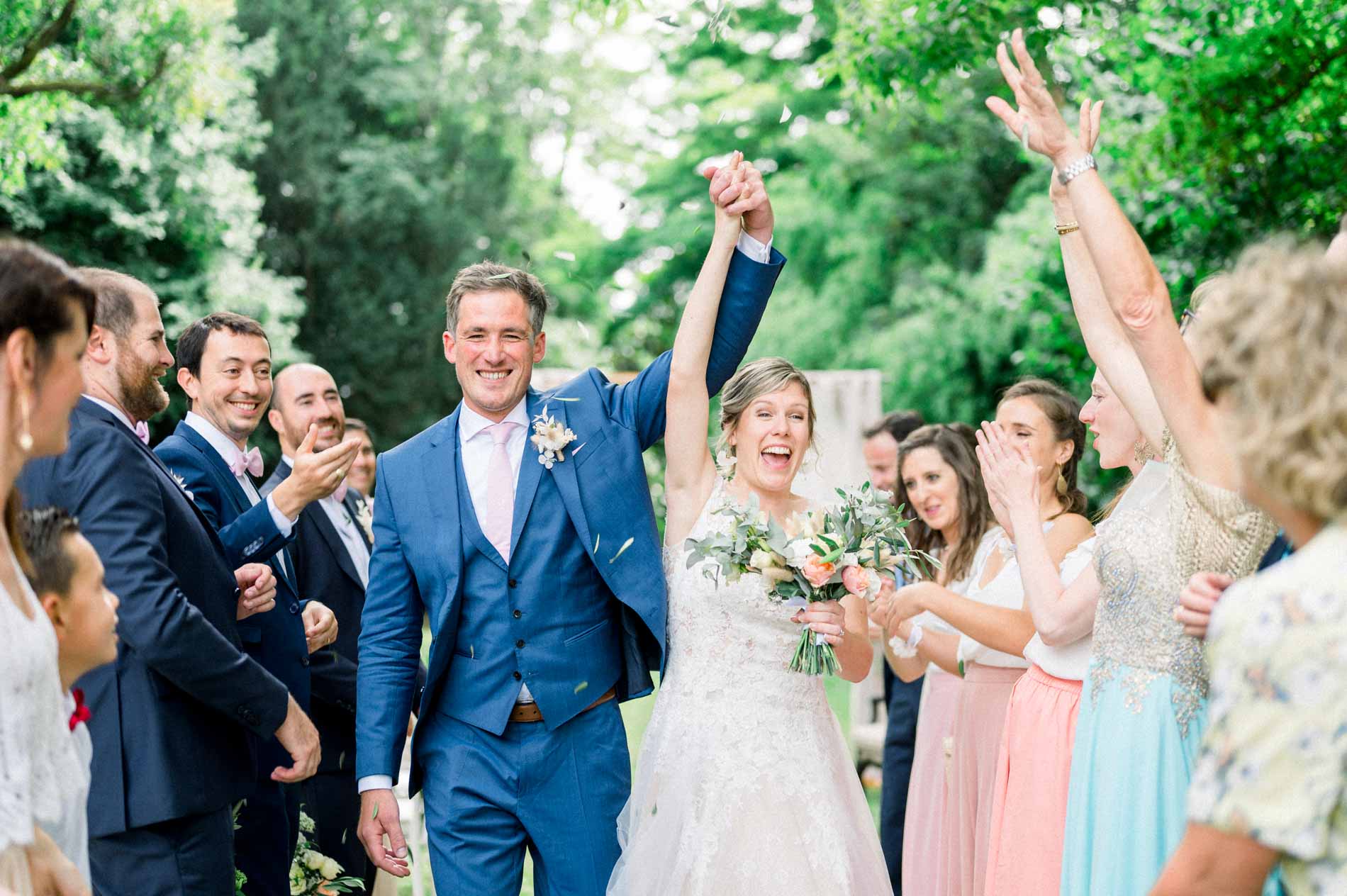 Bride and groom cheered by their guests as they leave the ceremony