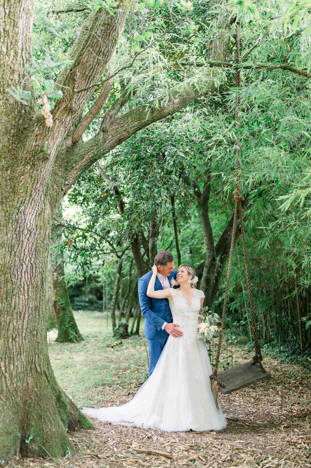 Bride and groom kissing at the foot of a tree in the Chartreuse woods