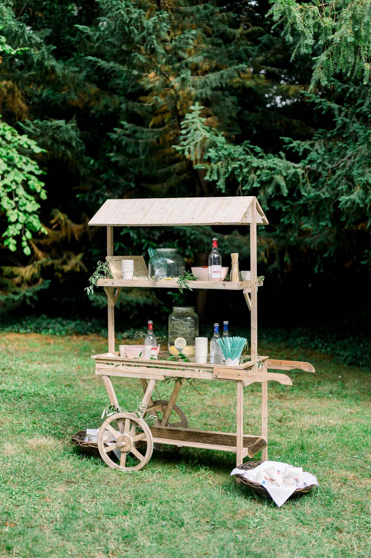 Wooden lemonade cart set up on the shaded lawn in the grounds