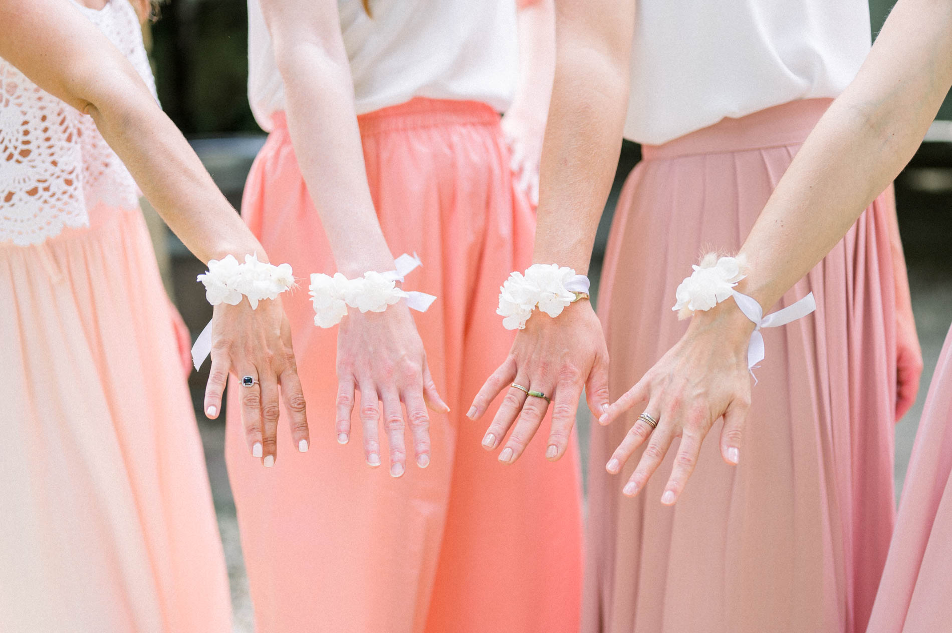 Bridesmaids' hands adorned with white flower wrist corsages