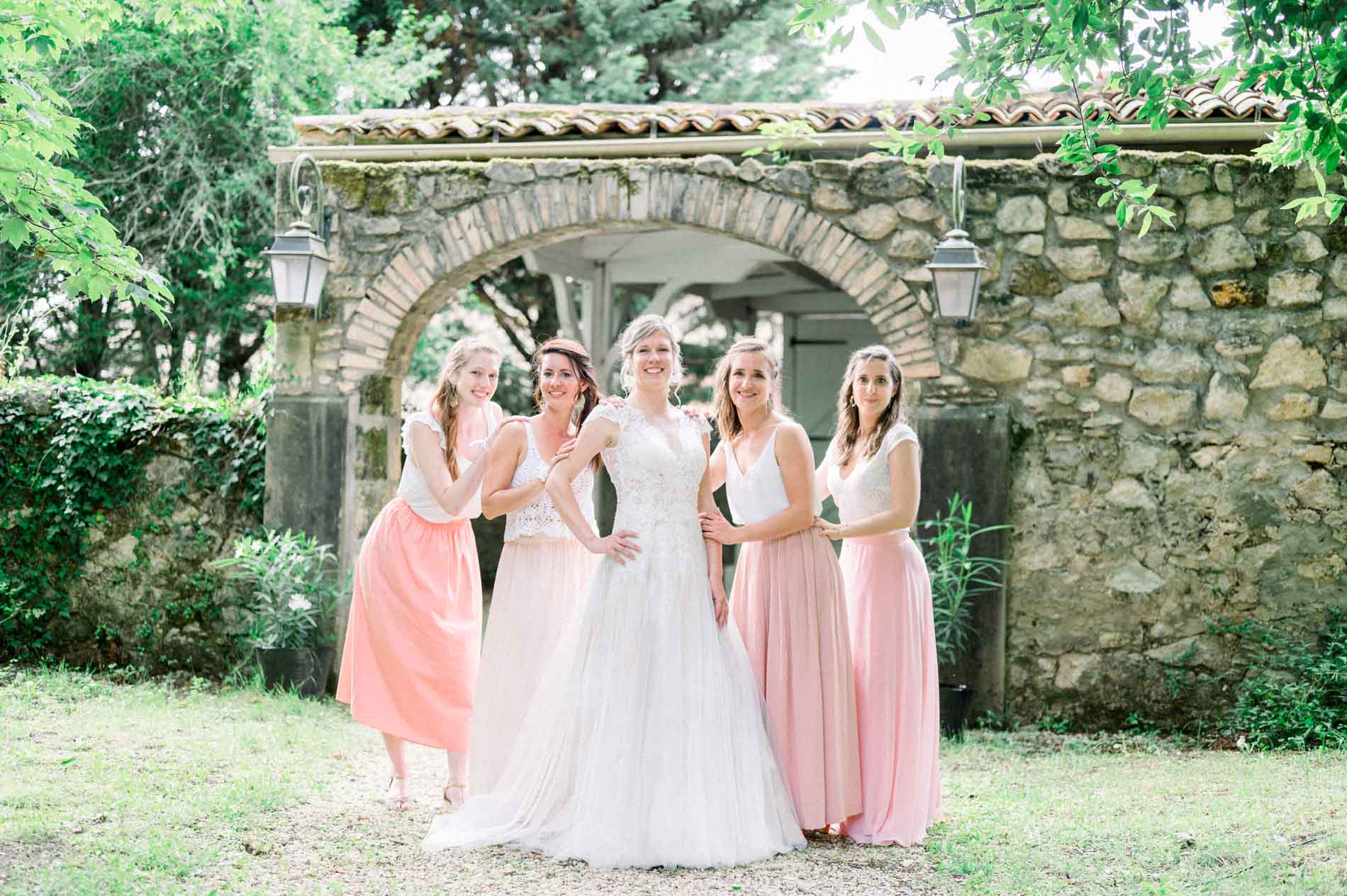 Bride and her bridesmaids before the stone archway of the Chartreuse des Eyres