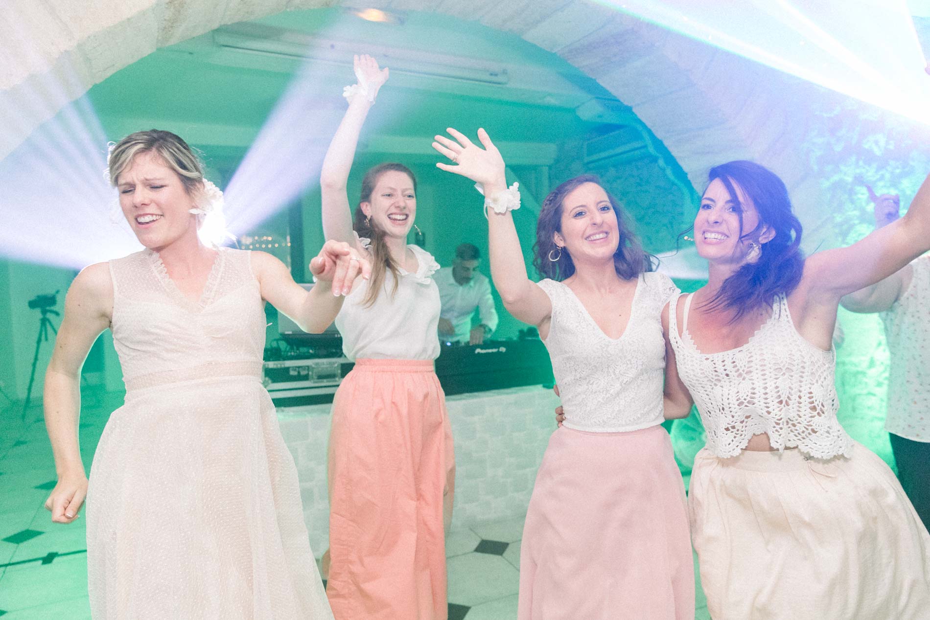 Bride and her friends raising their arms on the dance floor