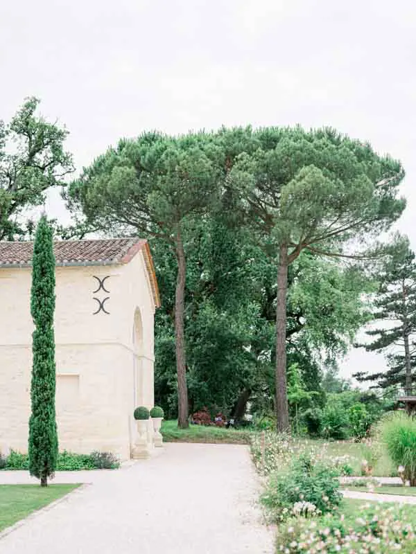 Gravel path lined with cypresses and umbrella pines at Château Gassies