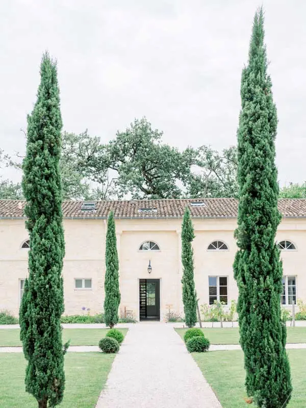 Central path framed by cypress trees leading to the Château Gassies outbuildings