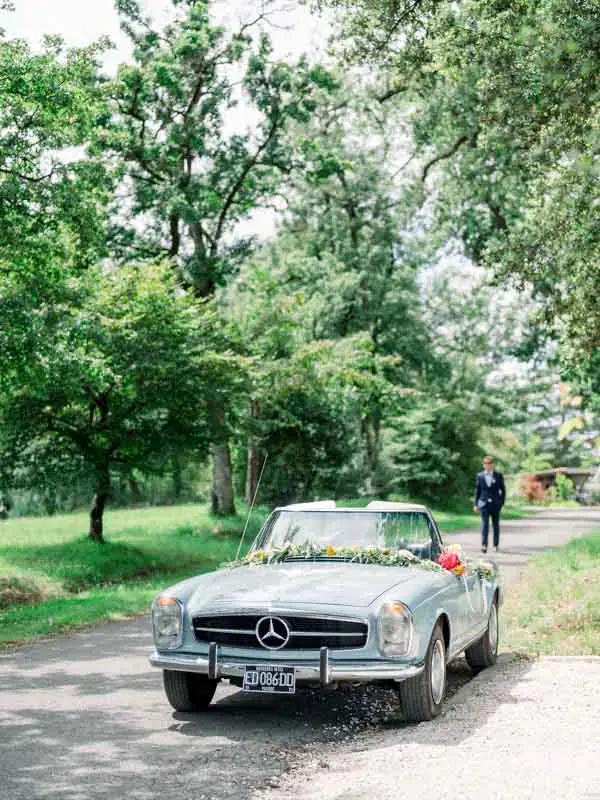 Vintage pale blue convertible decorated with flowers on the park drive