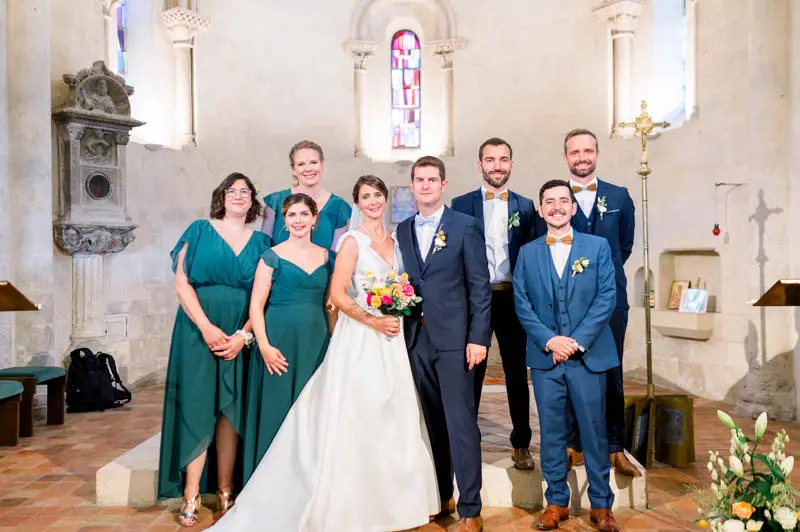 Group photo of the couple and their wedding party inside Bouliac church