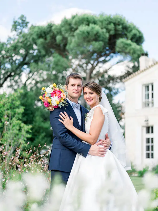 Couple embracing in the flower garden, colourful bouquet raised