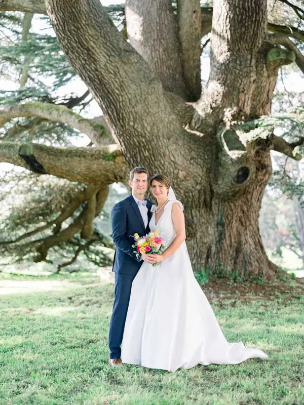 Bride and groom at the foot of an ancient cedar's gnarled trunk