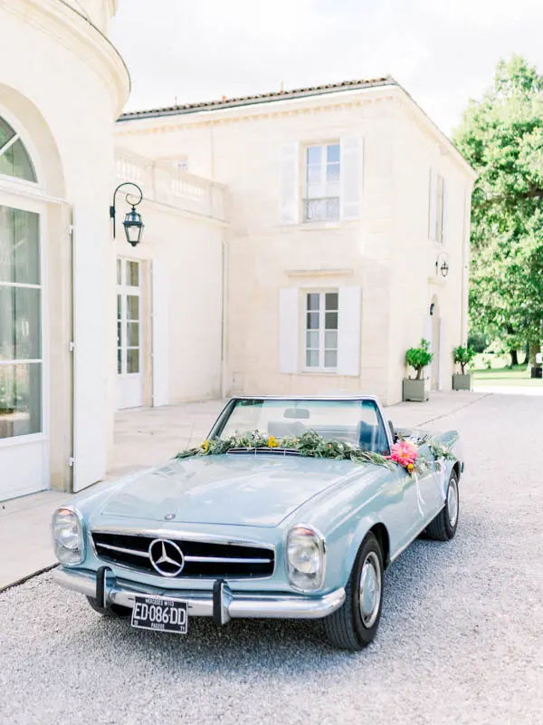 Flower-decked vintage convertible parked at the Château Gassies entrance