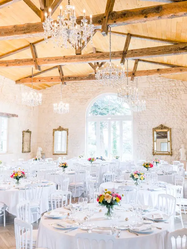 Château Gassies reception hall with crystal chandeliers and floral tables