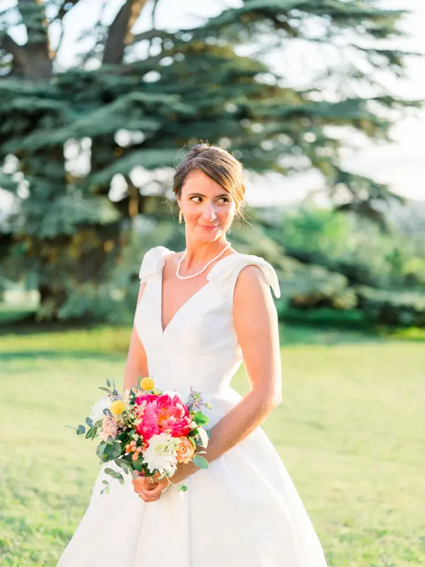 Portrait of the bride with her colourful bouquet in front of the great cedar
